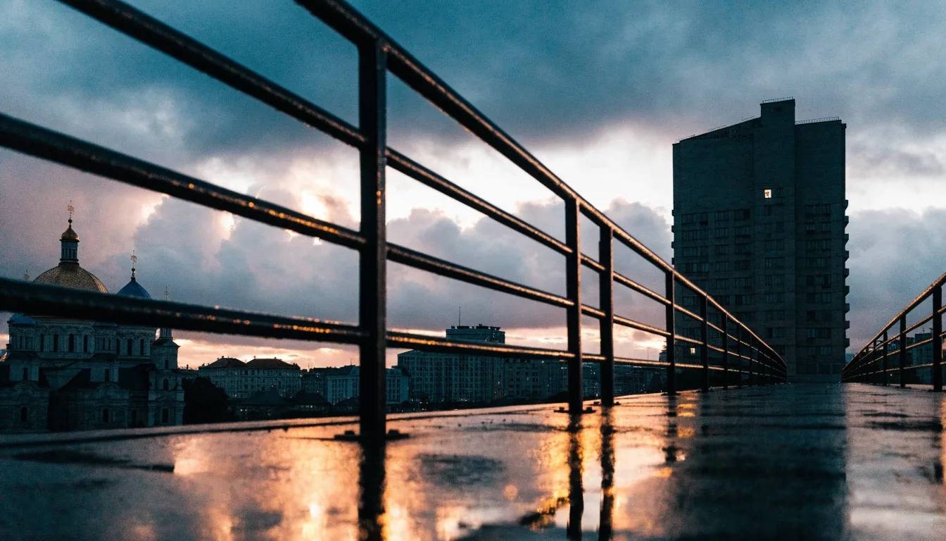 Avenida europea al atardecer bajo la lluvia, con luz de sodio sobre el asfalto