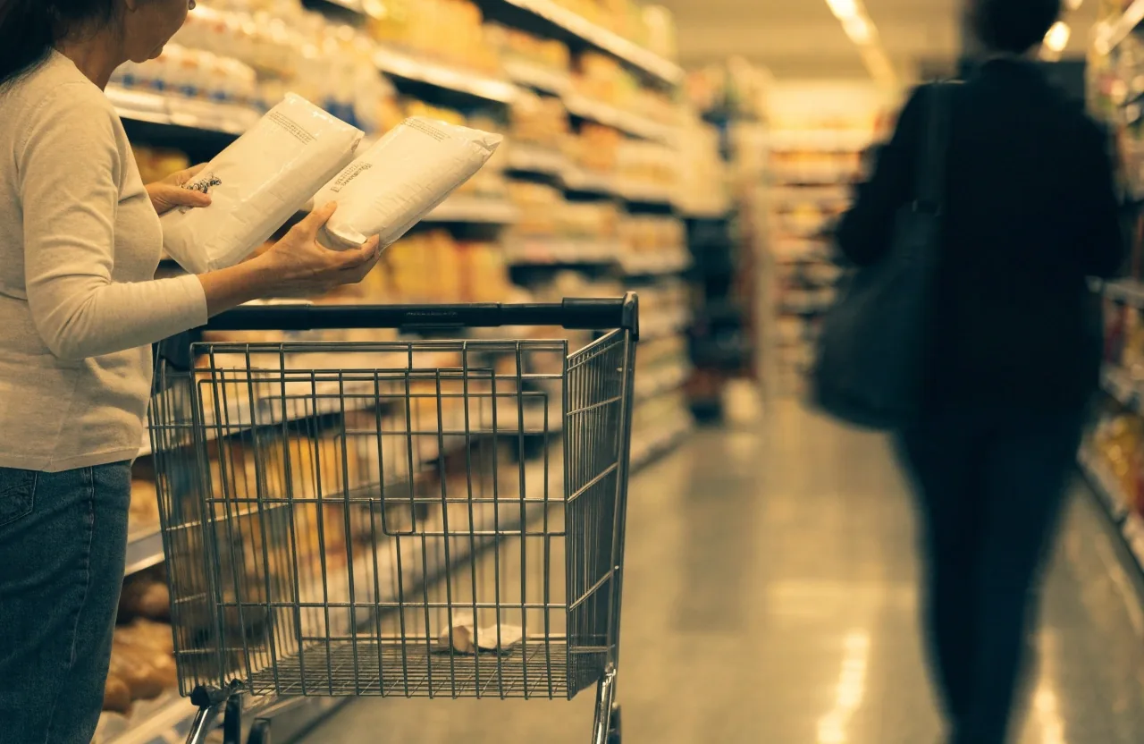 Estante de supermercado de cerca con una mano alcanzando un producto