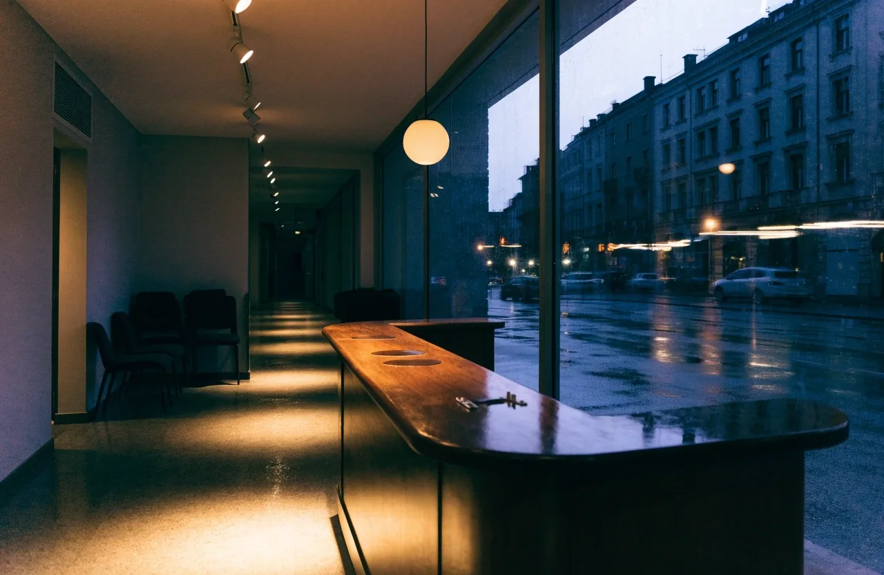 Fachada de un edificio de oficinas en Barcelona al atardecer, después de la lluvia, vista desde la acera de enfrente.