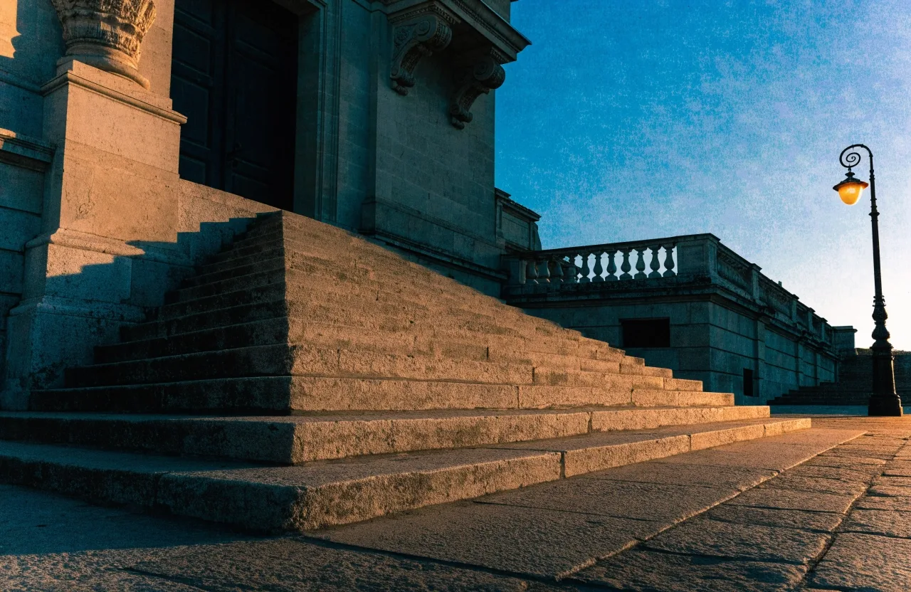 Escalinata de acceso a un edificio institucional al atardecer, vista desde la plaza
